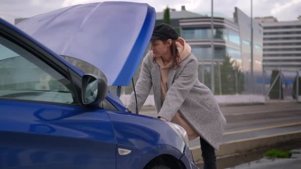 Car Breakdown on the Road in City Female Driver is Viewing to Under Hood Space