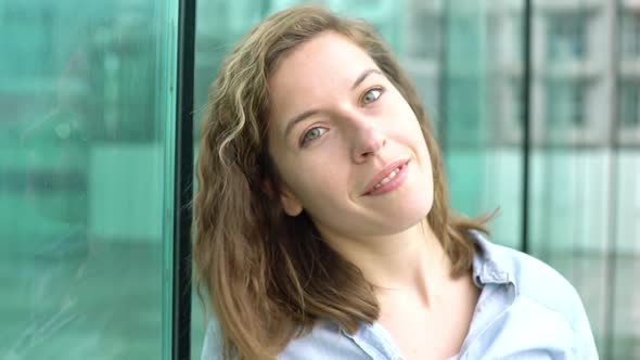 Young woman smiling cheerfully outdoors, portrait