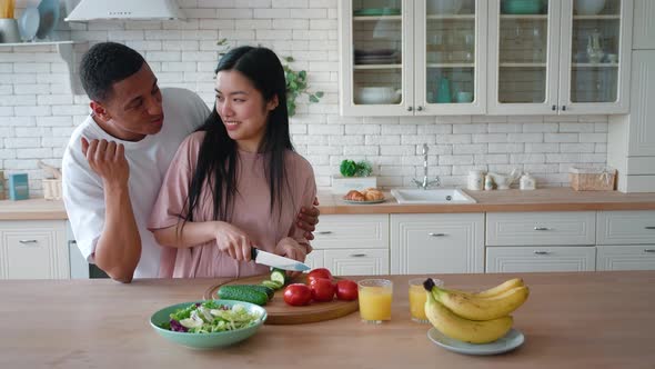 Overjoyed Mixed Race African American Man and Asian Woman Enjoying Cooking Healthy Tasty Vegetarian