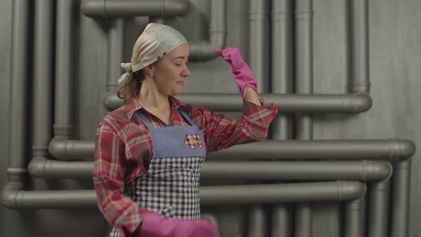 Housewife in Rubber Gloves Showing Muscular Strength