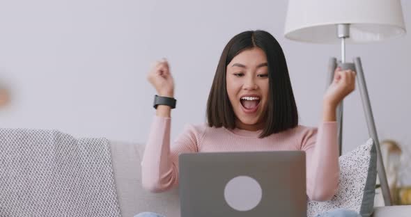 Happy Asian Lady Enjoying Success, Reading E-mail on Laptop at Home, Slow Motion