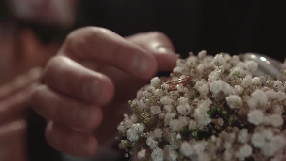 Groom Takes an Engagement Ring Lying in Flowers During a Wedding Ceremony Closeup Slow Motion
