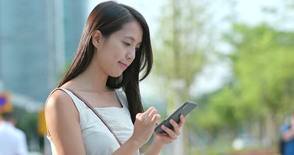 Asian woman use of mobile phone in city