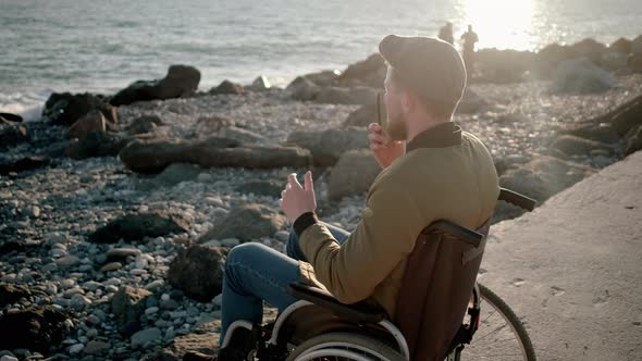 Disabled Man Talking on Mobile on the Shore
