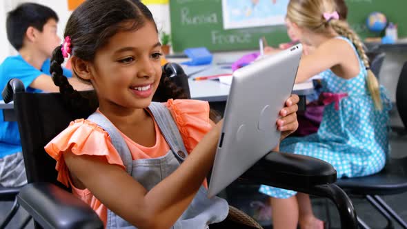 Disabled schoolgirl using digital tablet