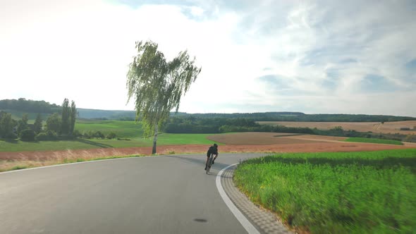 Female cyclist cycling on countryside road