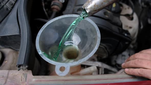 Man Pouring Oil in Car