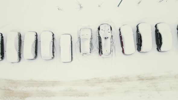 Cars in a Parking Lot Covered with White Snow After a Blizzard