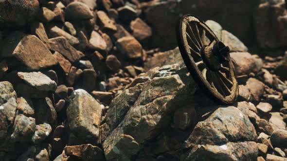 Old Wooden Wheel on Rocks alt