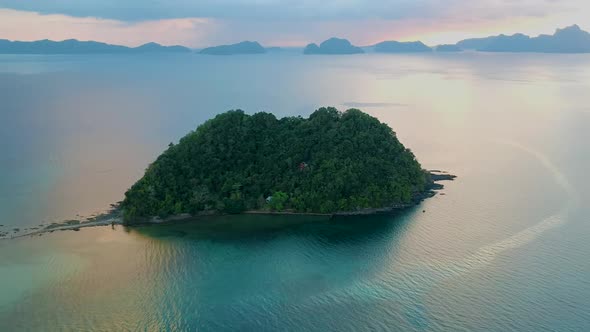 Aerial pan of Depeldet Island at sunset off the coast of Las Cabanas beach, El Nido, Palawan, Philip