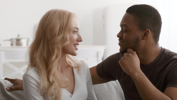 Loving Black Husband Touching Wife's Chin Flirting Sitting At Home