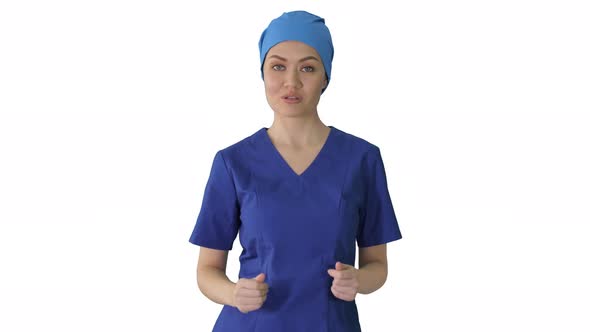 Smiling Female in Blue Medical Uniform Advertising Clinic Services While Walking on White Background