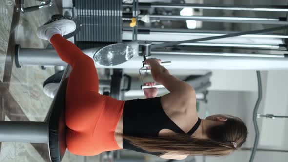 Fitness Woman Working Out in the Gym on a Shoulder Muscle Training Machine Vertical Video