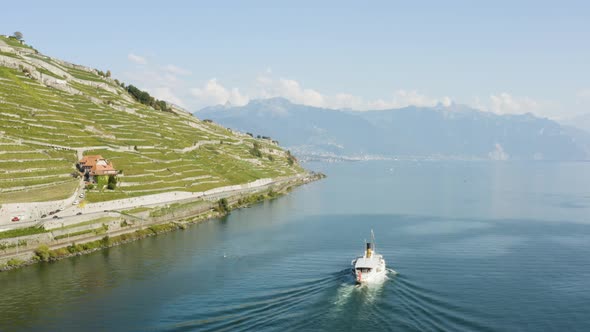 Aerial shot following CGN Belle-Epoque steam boat on Lake Léman in front of Lavaux vineyard. Swiss t