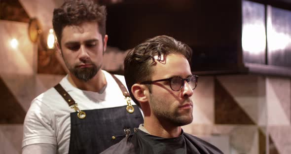 Male barber tying client apron