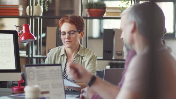 Businesswoman Discussing Papers with Colleagues at Office Meeting