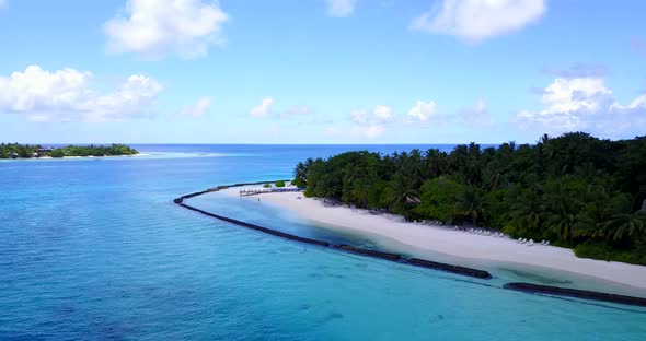 Tropical flying tourism shot of a sunshine white sandy paradise beach and blue ocean background in h