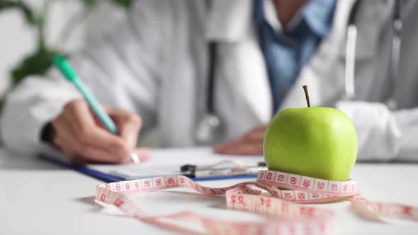 Girl Nutritionist Writes Sitting At The Desktop. Hands Of A Girl Writing Write Out A Prescription