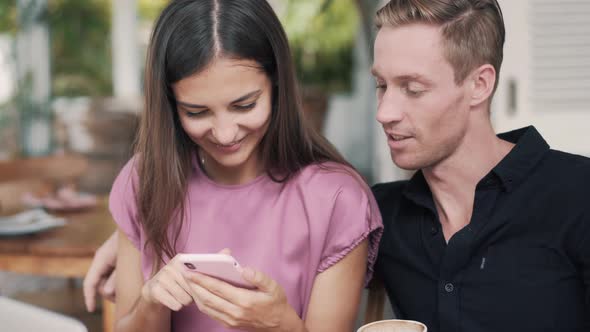 Portrait of Young Man and Woman in Cafe, Use Smartphone, Looking at Screen, Talking