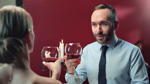 Happy Male Toasting Clink Glasses of Wine with Sexy Woman