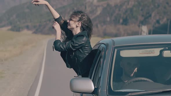 Gorgeous Lady in Leather Jacket Leans Out of Car Window