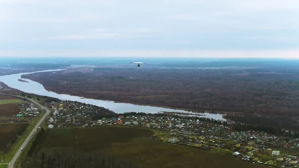 A Flight of a Hang Glider Over the River and Suburb