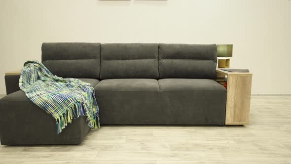 Stylish Black Corner Sofa with a Wooden Sidewall and a Cozy Plaid