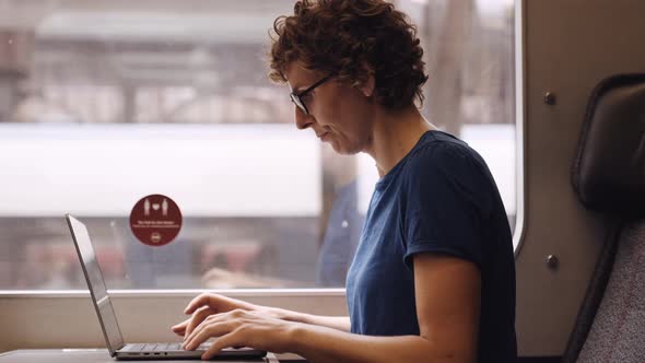 Woman in Glasses Working on a Laptop While Waiting for the Train Departure