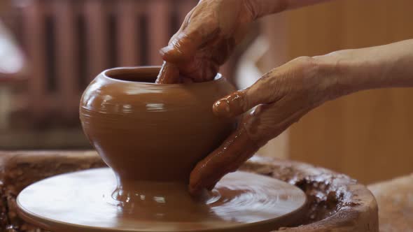 Elderly Hands of a Potter Creating an Earthen Jar on the Circle