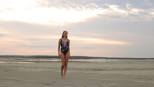 Flirty Woman in Black Bikini Walking Along Sandy Beach