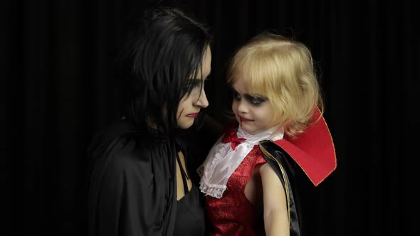 Woman and Child Dracula. Halloween Vampire Make-up. Kid with Blood on Her Face