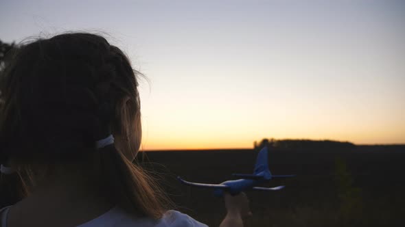 Little Female Child Holding in Hand a Plane at Countryside