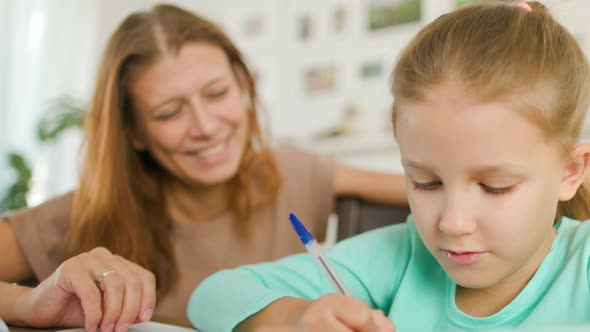 Girl Schoolgirl With A Woman Mother Does Home Lessons