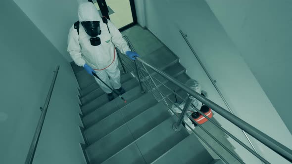 Disinfectors Clean Stairs in Office Building with Antiseptics.