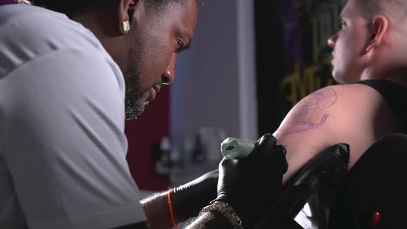 Cinematic Slow Motion Shot of a Tattoo Artist Creating Body Art at the Tattoo Studio