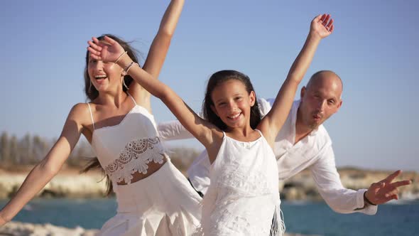 Joyful Little Girl Smiling Looking at Camera As Teenage Sister and Father Bending to Sides Posing