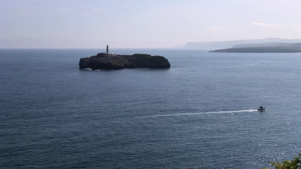 A small island with a lighthouse in the ocean