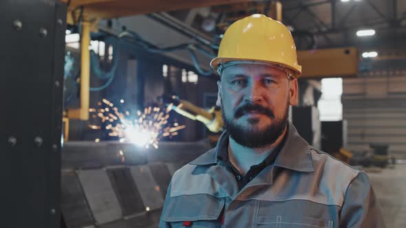 Man Posing in Foreground of Welding