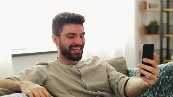 Man with Smartphone Having Video Call at Home