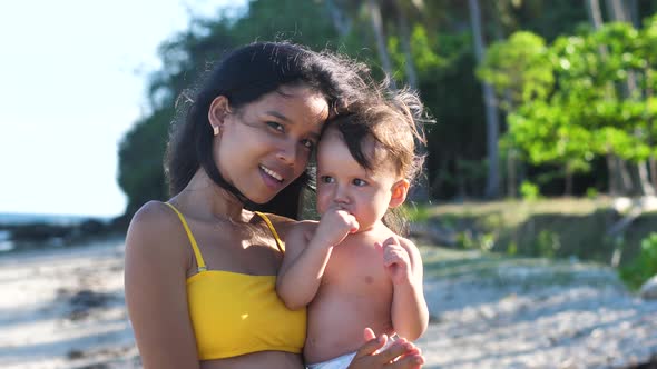 Happy and Beautiful Young Asian Mother Teaching Her Baby to Clap Hands