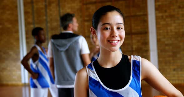 High school girl standing with basketball in the court 4k