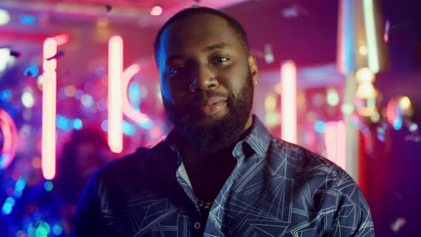 African American Man Trying To Spit Foil at Party. Guy Posing Under Confetti