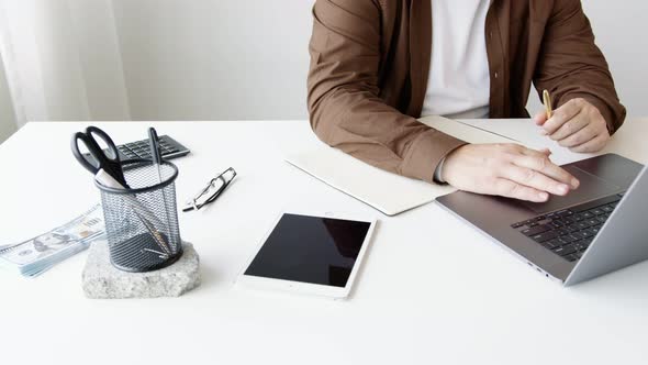 close-up of a desktop with a  laptop and hands