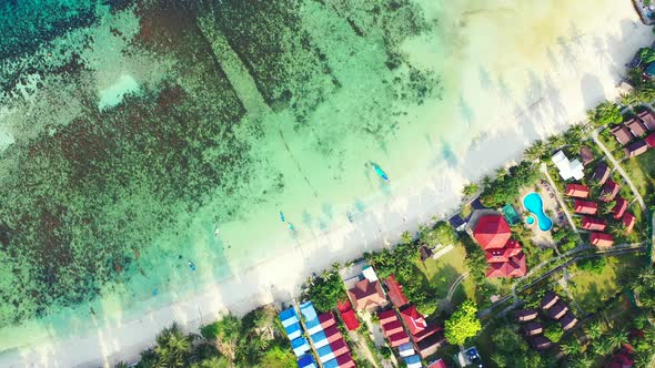 Natural fly over tourism shot of a paradise sunny white sand beach and aqua turquoise water backgrou