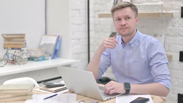 Businessman Thinking While Working on Laptop