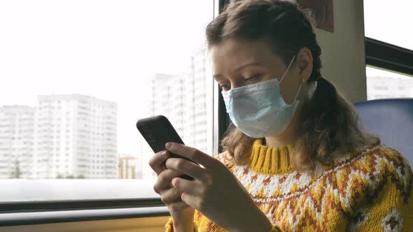 Woman in Mask Surfs Internet with Cellphone in Transport