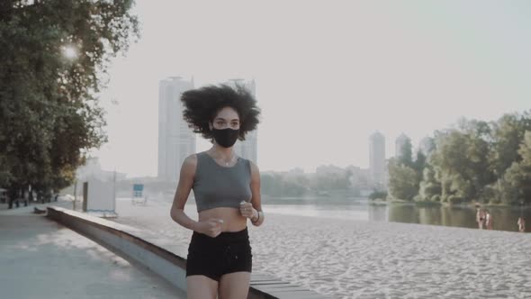 Attractive Slim Girl Wearing a Medical Mask Stretching Her Legs Near the River