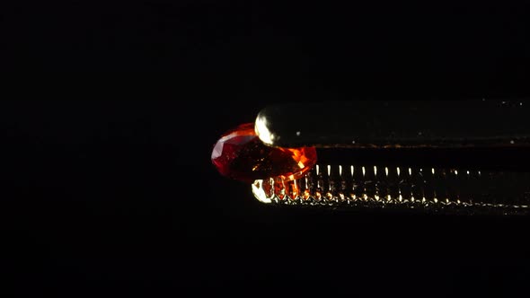 Natural Hessonite Brown Garnet Gemstone in the Tweezer on the Turn Table