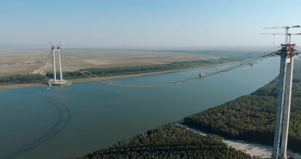 Danube River Spanned By Braila Bridge Under Construction With Towers And Main Cables In Romania. - a