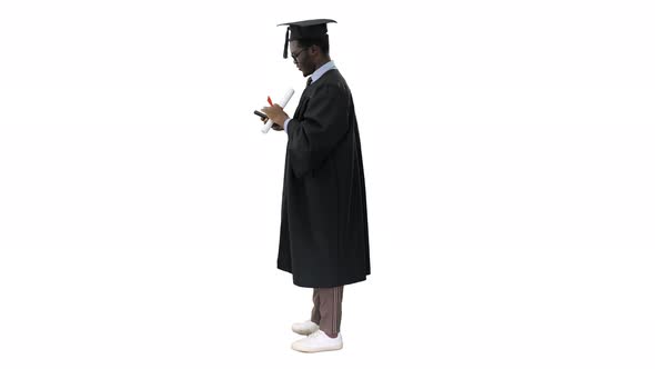Happy African American Male Student in Graduation Robe Taking Phone Selfies with His Diploma on